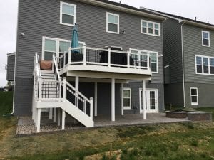 Ground view of new composite deck on rear of home with patio and fire pit beneath